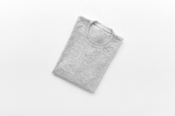 Grey T-shirt folded over white background