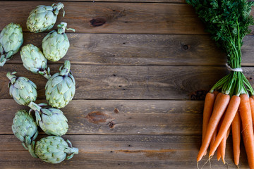 artichokes and carrots on wooden table