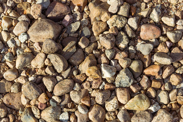 Shore stones of different sizes in the sunlight