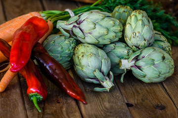 artichokes, peppers and carrots on wooden table