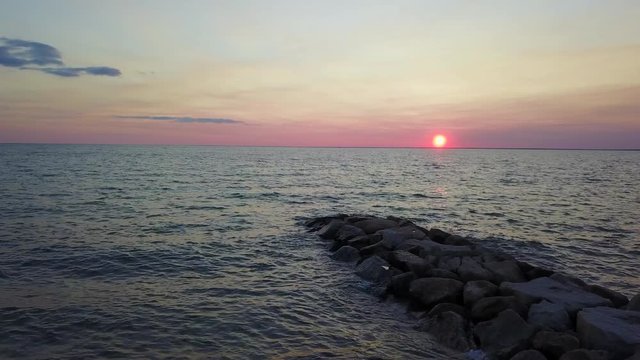 Slow drone flyover of a peaceful jetty at sunset. Shot In Cape Cod MA