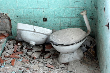 Abandoned house bathroom with old broken toilet, cracked sink, ruined tiles, a lot of cobwebs and...