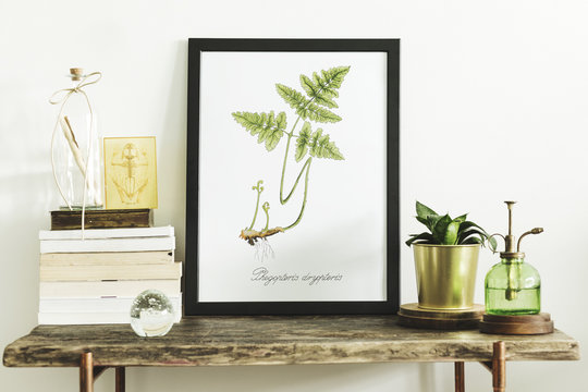 Stylish scandinavian composition of wooden console with mock up poster frame, books, plants, sprinkler and accessories. Modern composition of home interior.