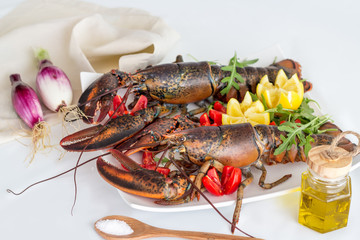 TWO RAW ORGANIC LOBSTERS WITH LEMON AND TOMATOES. INGREDIENTS FOR CATALAN LOBSTER.SELECTIVE FOCUS.
