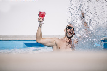 attractive man inside pool  red drink