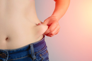Naklejka premium women with overweight show fat on the stomach