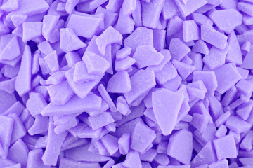 Candy background, copy space. Closeup of pile pastel chocolate candies. Candy texture. Food pattern. Sweets background. Violet abstract background. Top view, flat lay