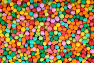 Fototapeta na wymiar Colorful candies background, copy space. Nuts in multi-colored glaze dragee. Sweet candies spreading pastry decoration. Pile of colorful coated candy. Sweets texture, pattern. Top view, flat lay