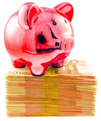 tirelire petit cochon rouge sur liasses de billets, concept épargne improductive 