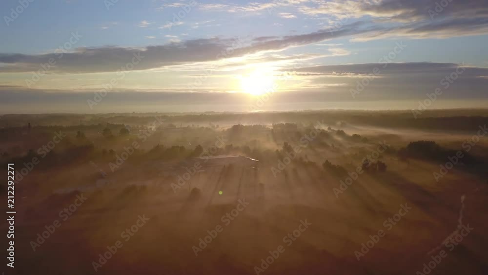 Wall mural beautiful aerial shot of thick layer of fog on fields during sunrise with expanse and endless skylin