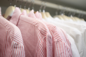 Fototapeta premium Striped business shirts on hangers in a wardrobe with shallow focus