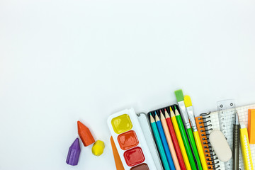 Obraz premium school stationary and tools for kids. notebook, paint, pencils on white desk surface, flat view
