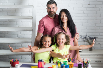 Happy family smiling at table with colorful paints