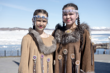 Two chukchi girls in folk dress against the Arctic landscape - obrazy, fototapety, plakaty