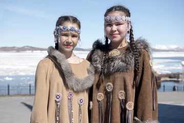 Fotobehang Two chukchi girls in folk dress against the Arctic landscape © Konstantin Shevtsov
