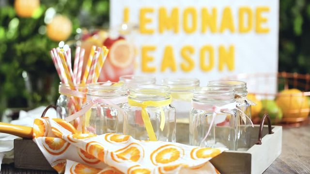 Step by step. Pouring raspberry lemonade with fresh lemons and raspberries in drinking mason jars