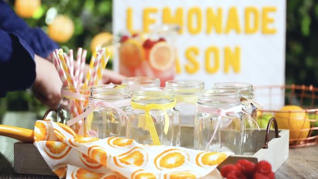 Step by step. Time lapse. Pouring raspberry lemonade with fresh lemons and raspberries in drinking mason jars