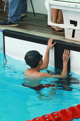 Swimmer with black swimming cap at starting block number 7