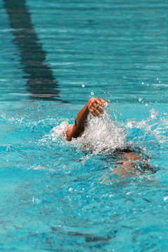 Swimmer swims backstroke or back crawl in a swimming pool for competition or race