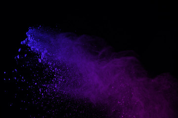 Freeze motion of colorful powder explosions isolated on black background. colored dust explosive on...