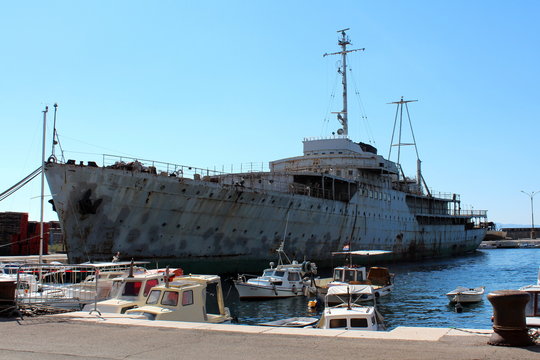 Old large historic rusted and beaten down ship called Galeb docked in harbor in Rijeka, Croatia, waiting patiently for restoration and better days while being available for tourists and explorers