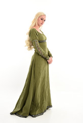 full length portrait of a blonde girl wearing green medieval gown, stand pose, isolated on white studio background.