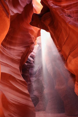 Upper Antelope Slot Canyon. Rays of light illuminating red sandstone cave in Upper Antelope Slot Canyon, Page, Arizona, USA. Navajo land. Amazing nature background with falling sand in a light beam.