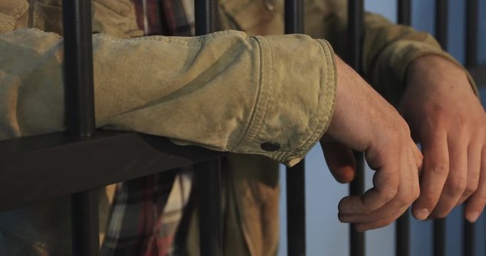 Homeless man with a beard in the prison cell.