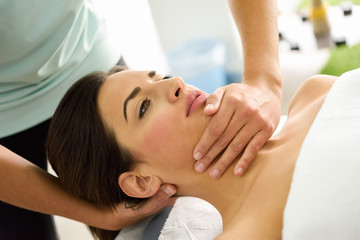 Obraz na płótnie Canvas Young woman receiving a head massage in a spa center.