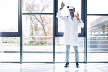Joyful dark-skinned man standing near window