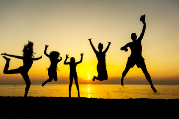 friends jumping in sunset