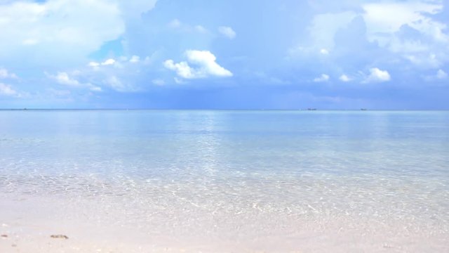 Amazing tropical beach. Ocean waves and cloudy sky background. White sand and crystal-blue sea. slow motion. 3840x2160, 4k