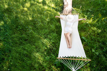 Woman resting in hammock outdoors. Sleeping outdoors.