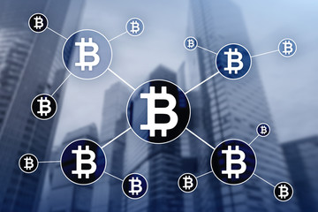 Bitcoin cryptocurrency and blockchain technology concept on blurred skyscrapers background.