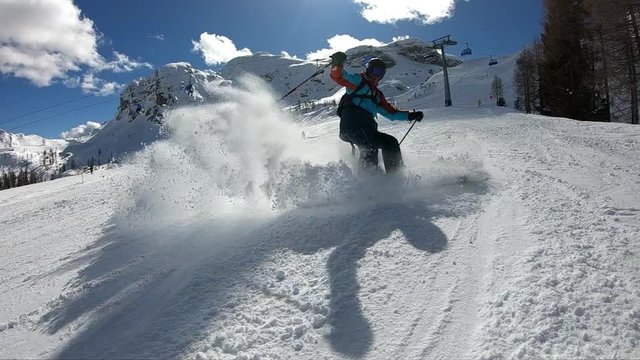 Young boy skiing.
A man enjoys skiing in the Alpine resort. Skier spraying snow into the camera. Stabilized footage. Slow motion.