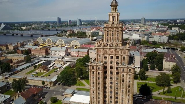 Drone shot of Academy of Sciences building, Stalin era architecture in former Soviet Union, flying towards old town and skyline of Riga, Latvia