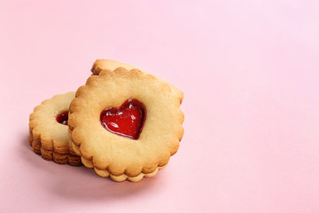 Traditional Christmas Linzer cookies with sweet jam on color background