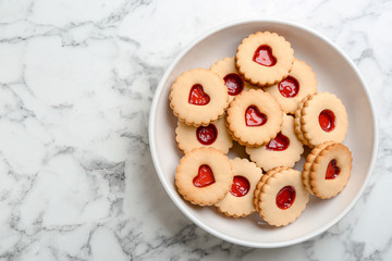 Traditional Christmas Linzer cookies with sweet jam on plate, top view