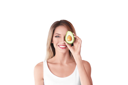 Portrait of young beautiful woman with ripe delicious avocado on white background