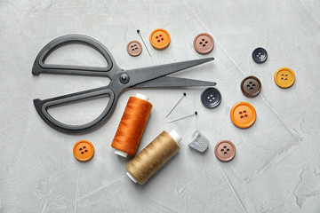 Set of tailoring accessories on light background, top view