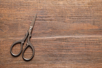 Vintage scissors on wooden background, top view. Tailoring equipment