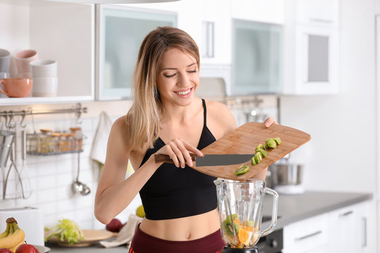 Young woman preparing tasty healthy smoothie in kitchen