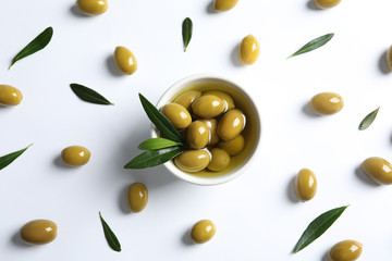 Flat lay composition with fresh olives in oil on white background