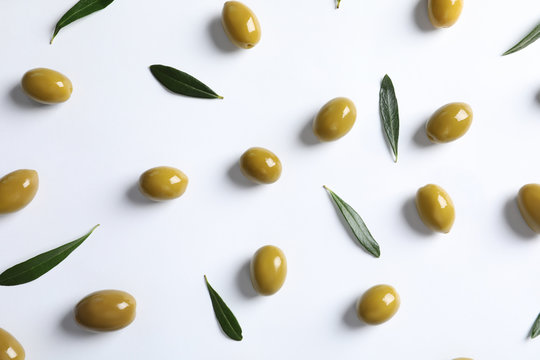 Flat lay composition with fresh olives covered with oil on white background