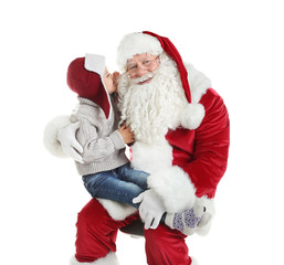 Little boy whispering in authentic Santa Claus' ear against white background