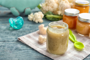 Jar with healthy baby food on table