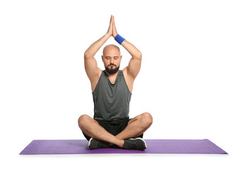 Overweight man practicing yoga on white background