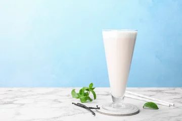 Papier Peint photo Lavable Milk-shake Glass with vanilla milk shake on table