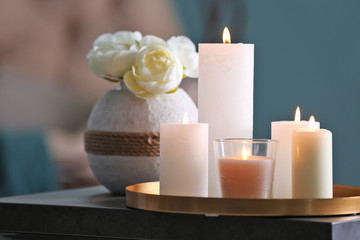 Fototapeta na wymiar Burning candles on table against blurred background