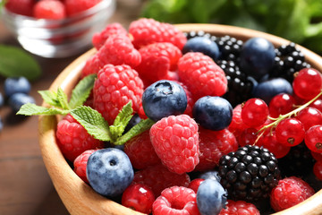 Bowl with raspberries and different berries, closeup